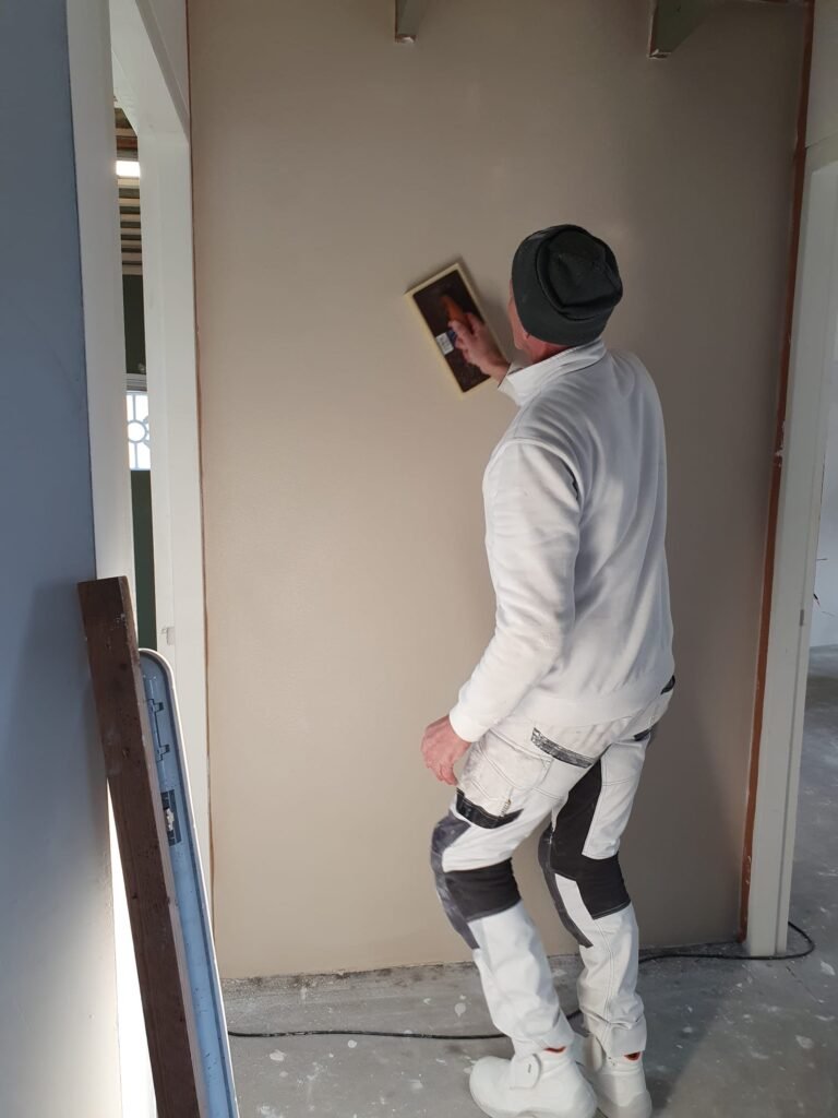 Stukadoor een muur ana het stucen in Rotterdam-Rijnmond